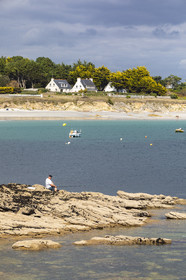 Pêcheur sur la pointe de Kerjean sur la commune de Trégunc. En arrière-plan, la plage de Kersidan